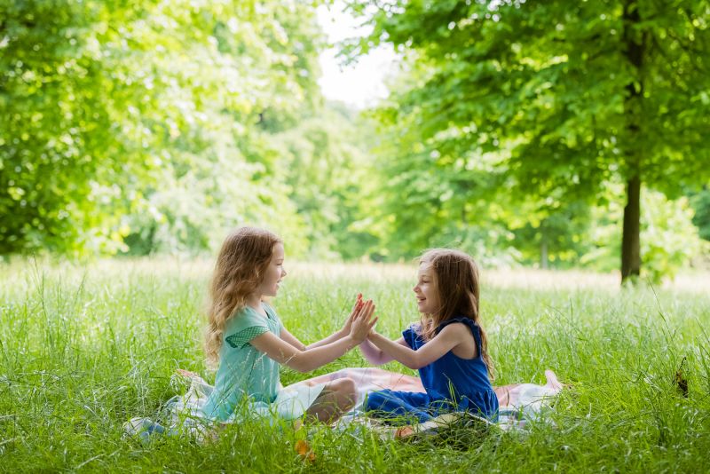 vibrant family photography of sisters playing pat-a-cake