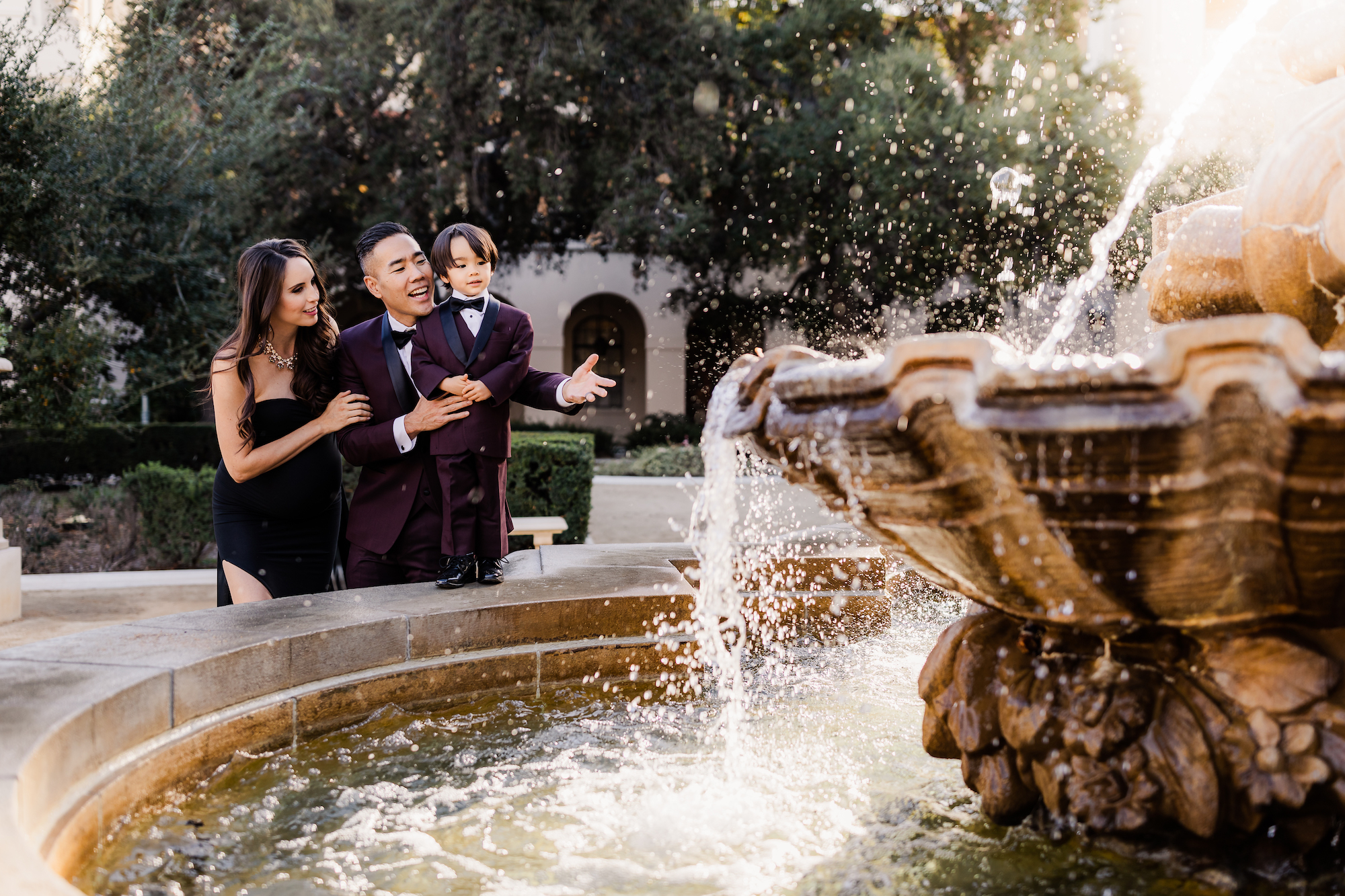 couple maternity photoshoot ideas with family by the fountain
