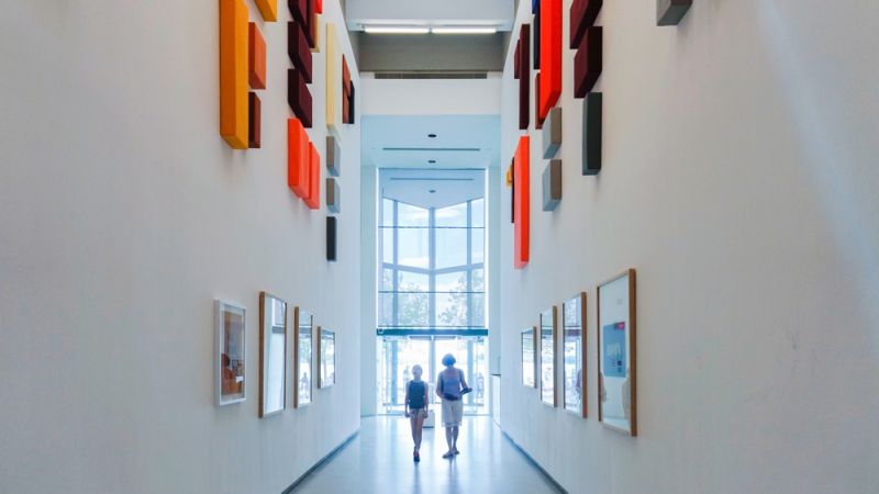 A long hallways displaying art on the walls.