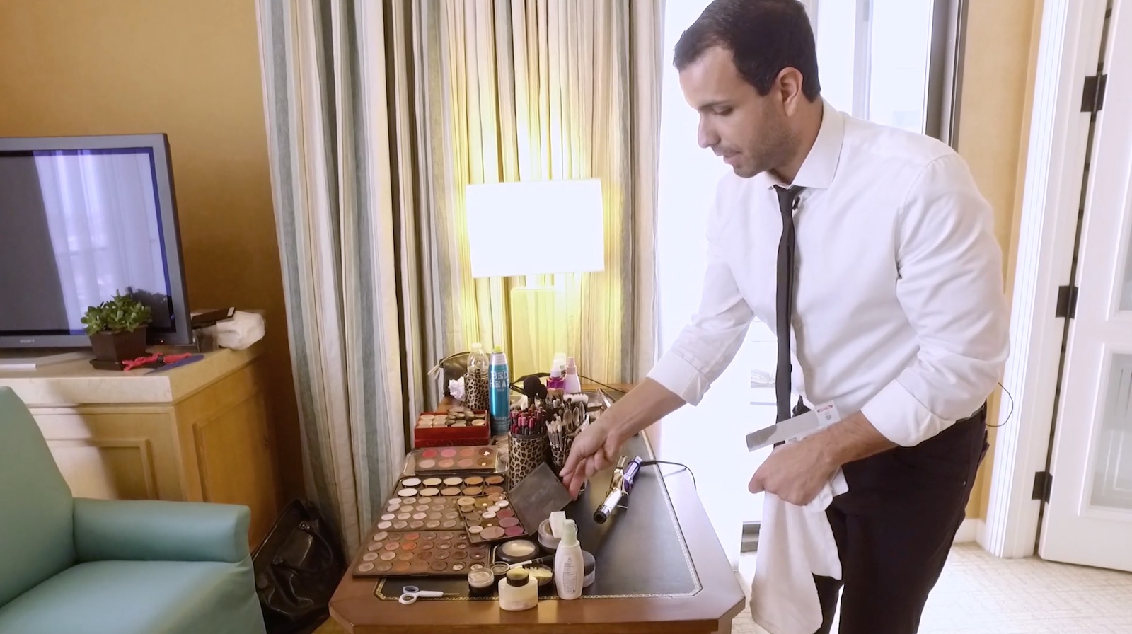 Makeup artist workstation with brushes and cosmetics spread across the table