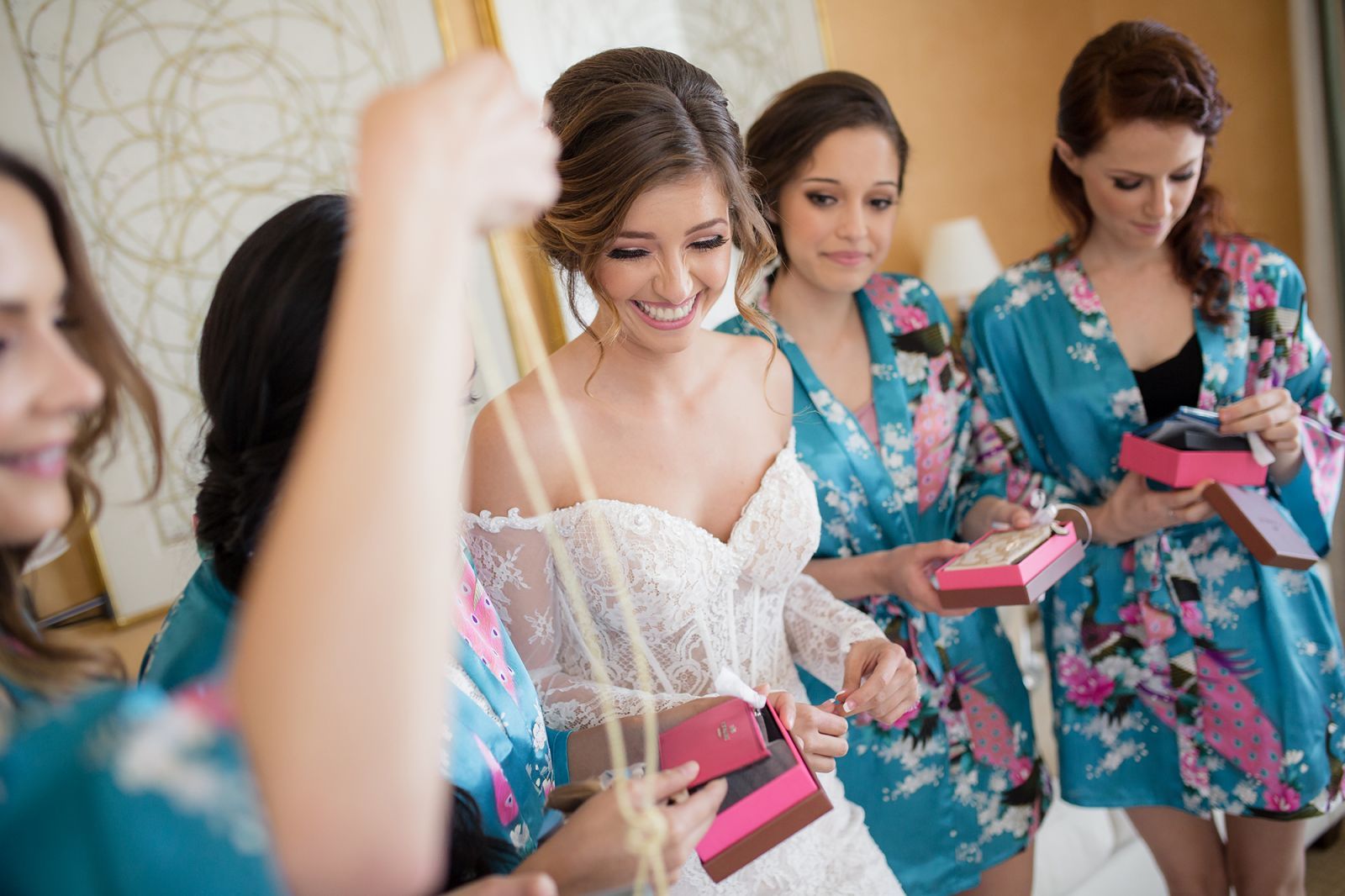 Bride having makeup applied during bridal prep with natural window light