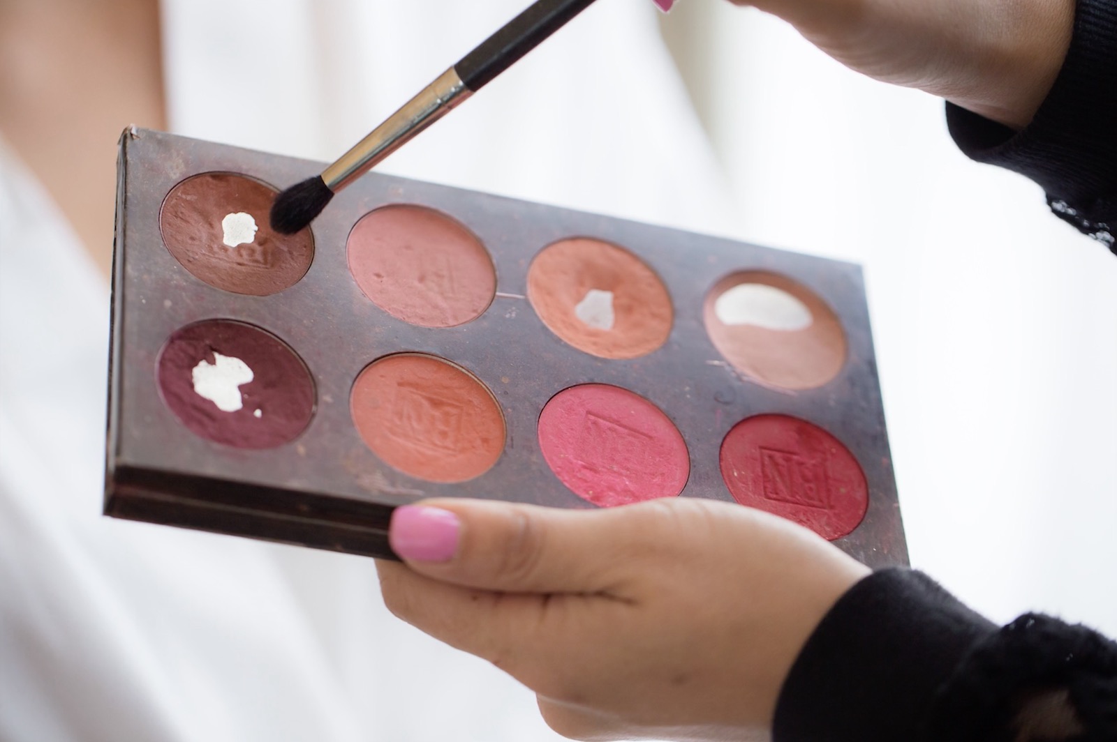 Closeup detail shot of a makeup artist brush collection and product palette