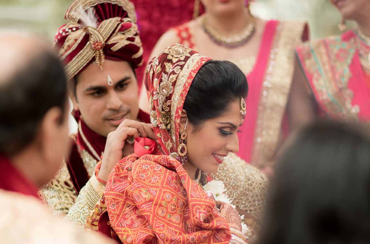 groom places necklace on bride