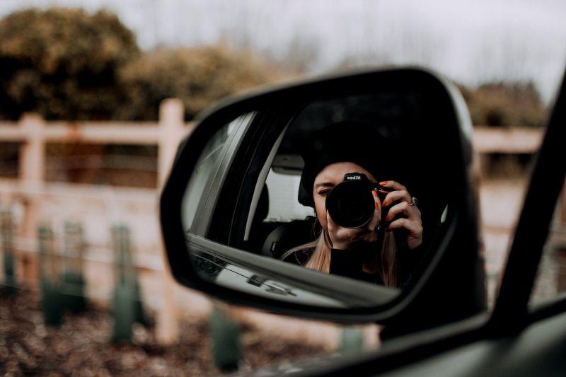 Reflection of couple in wing mirror of a car Stock Photo - Alamy