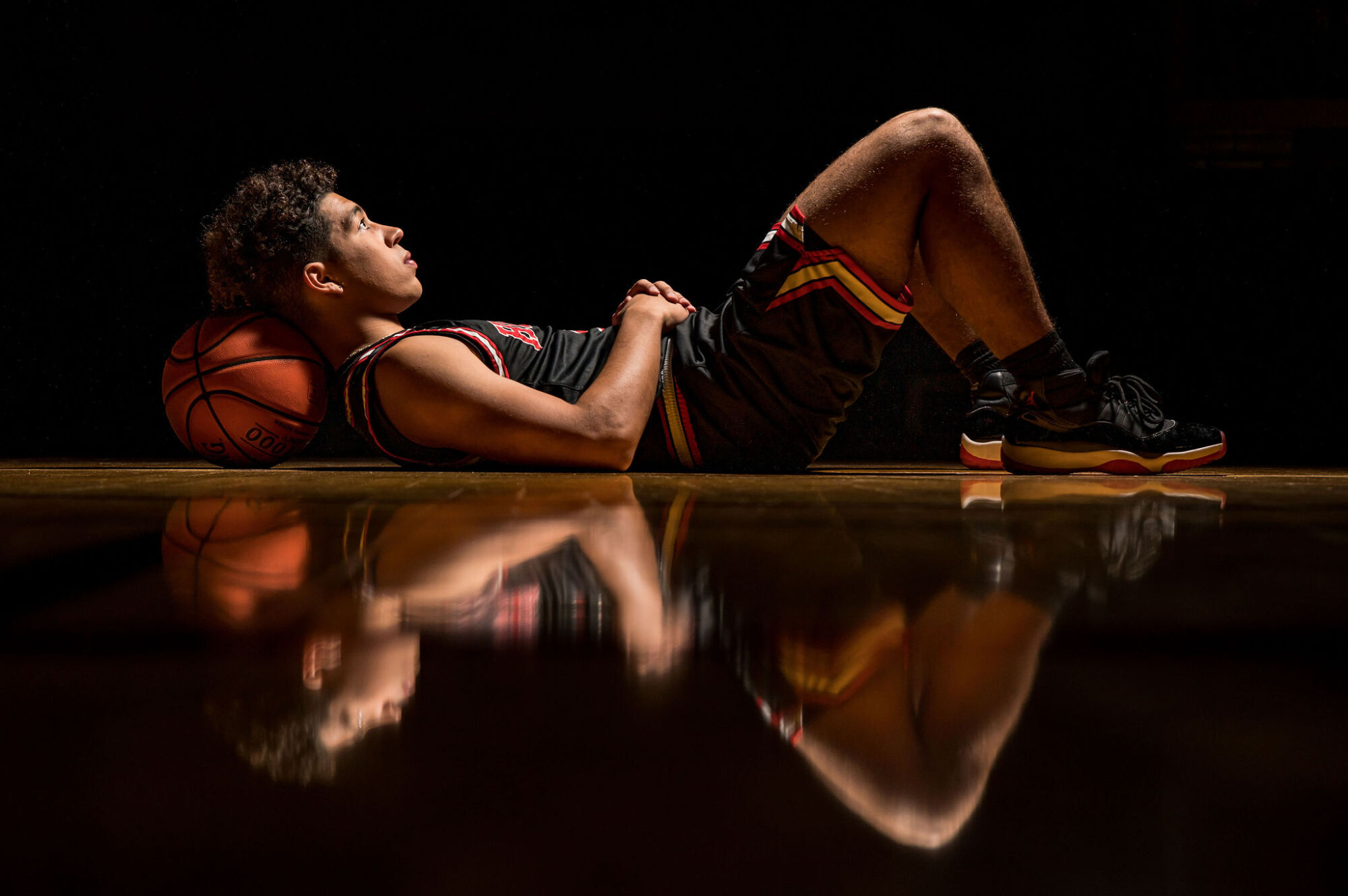 Male basketball player senior portrait posed on indoor court