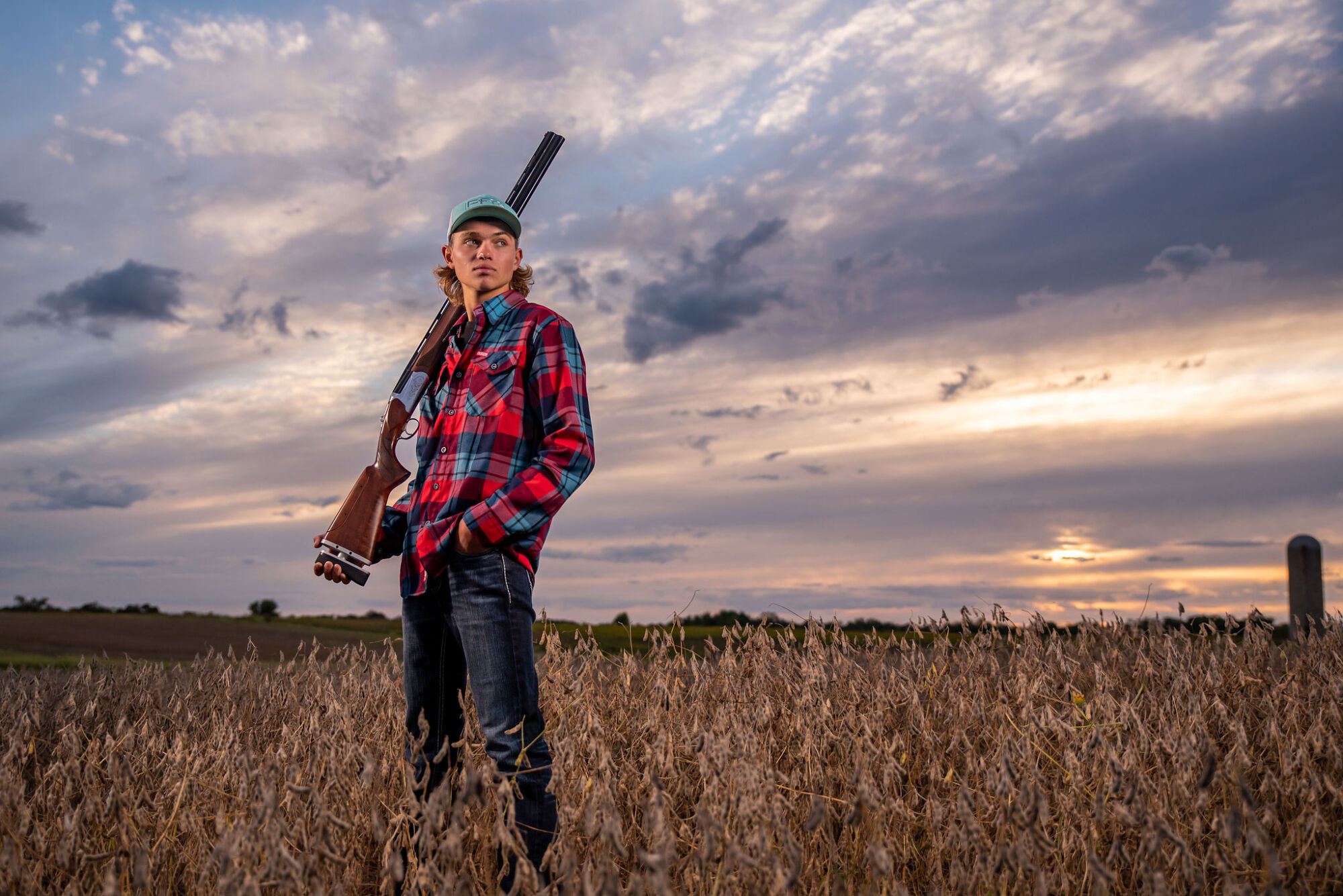Hunting senior portrait outdoors in camo with bow in wooded setting