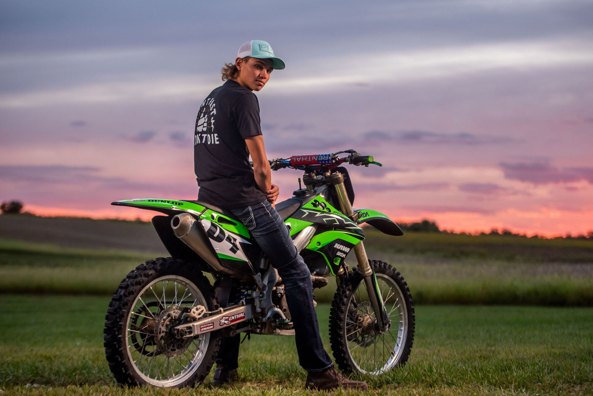 Motocross senior portrait on dirt bike with helmet and riding gear