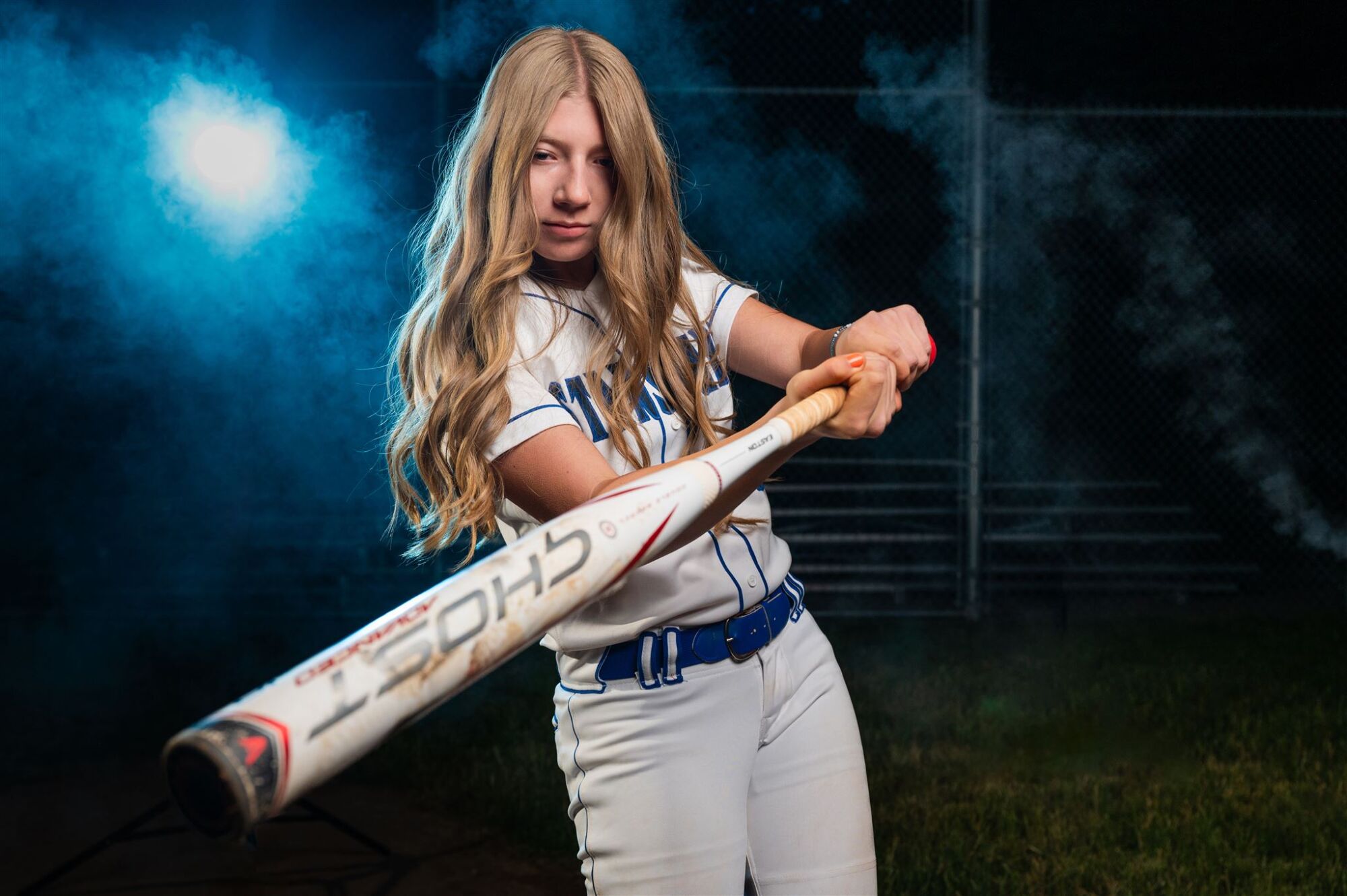 Utah softball senior photo with player in action pose on field