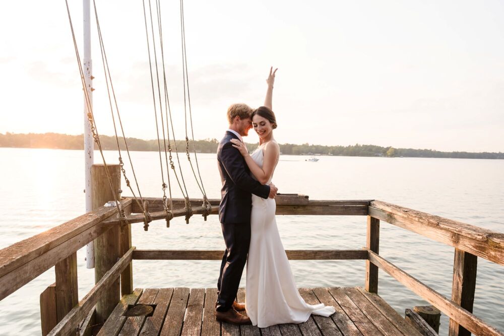 bride flashes peace sign on a dock