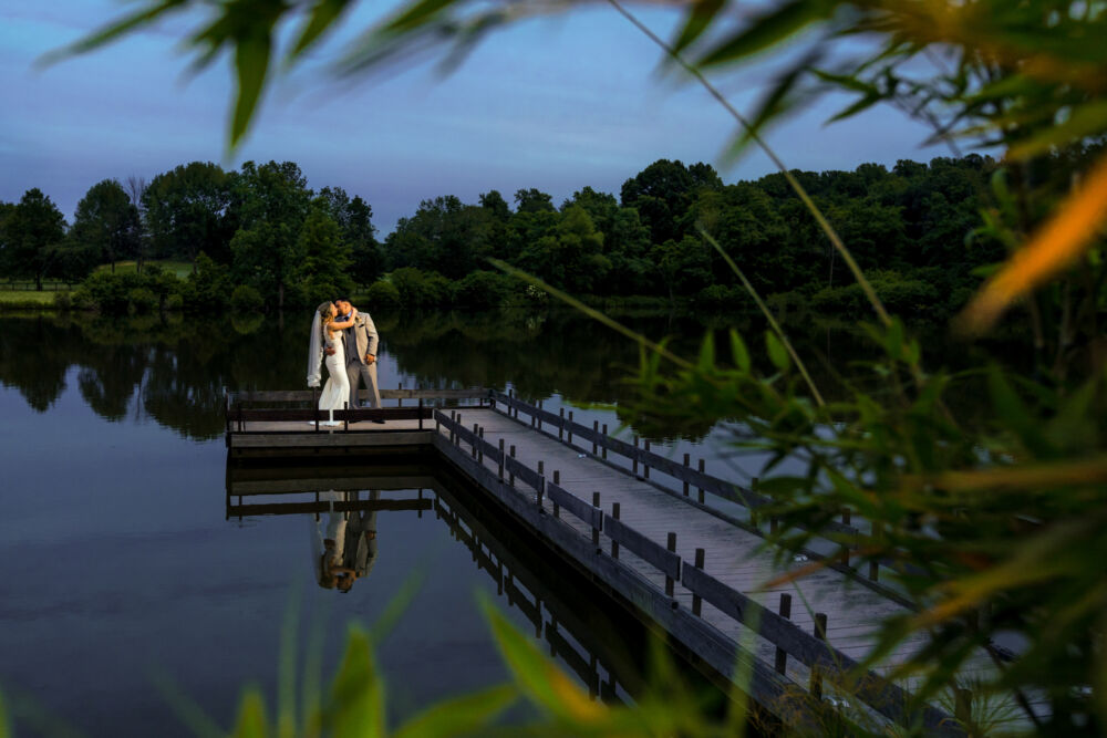 couple kisses at the end of a dock