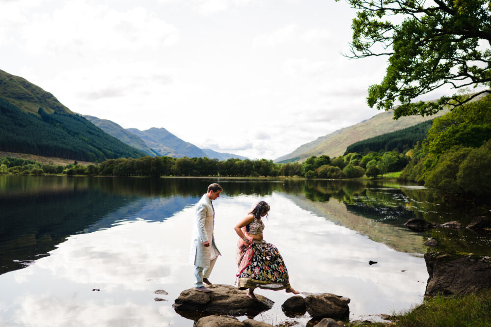 lake wedding photography couple walking on the rocks near the shoreline