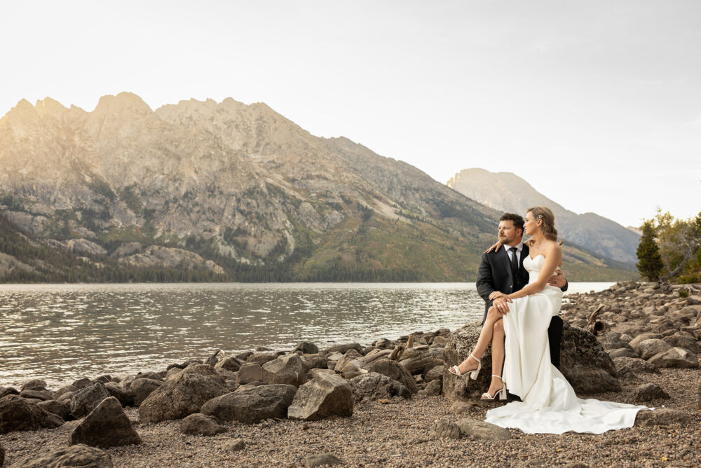 couple sitting near the shore in lake wedding photography example