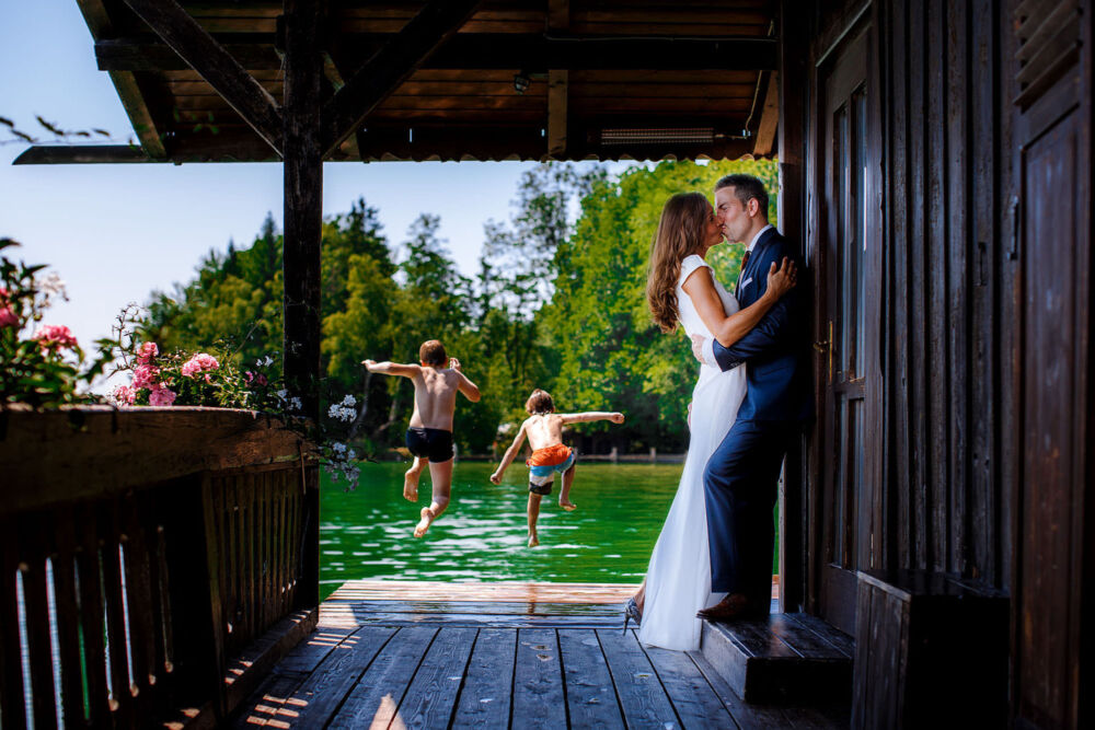 kids jump in water as newlyweds kiss