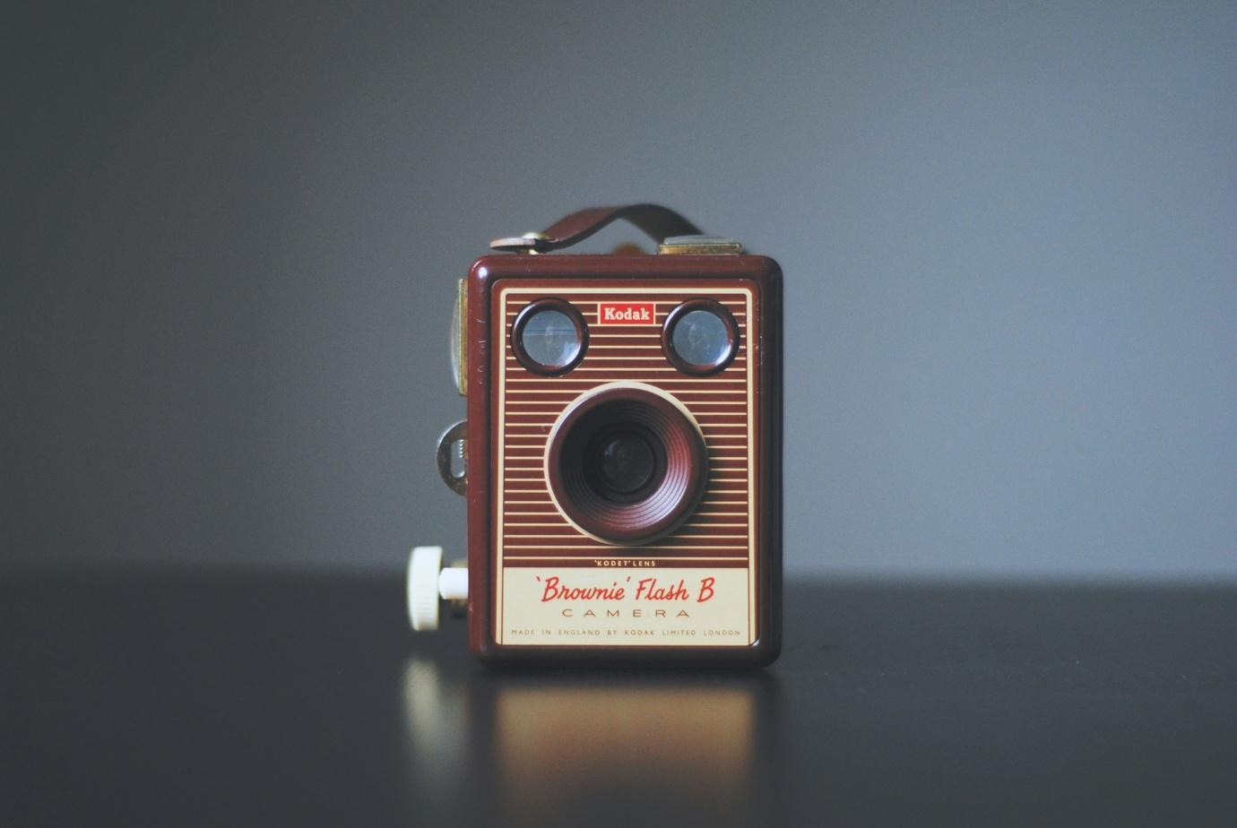 A vintage Kodak camera placed on a gray desk.
