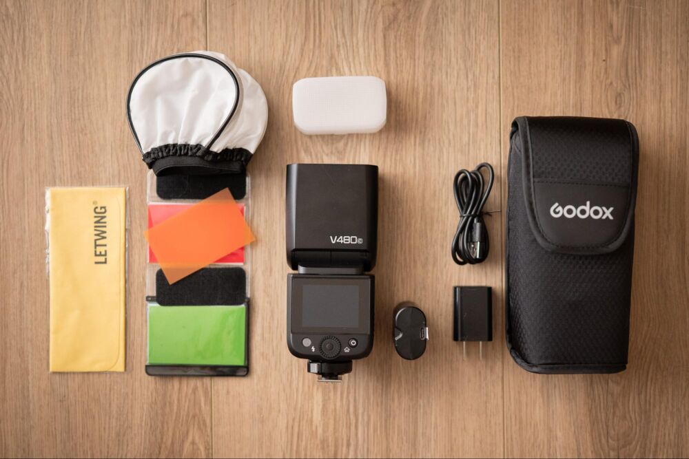 Flat-lay image of flash and accessories for Godox V480 Review