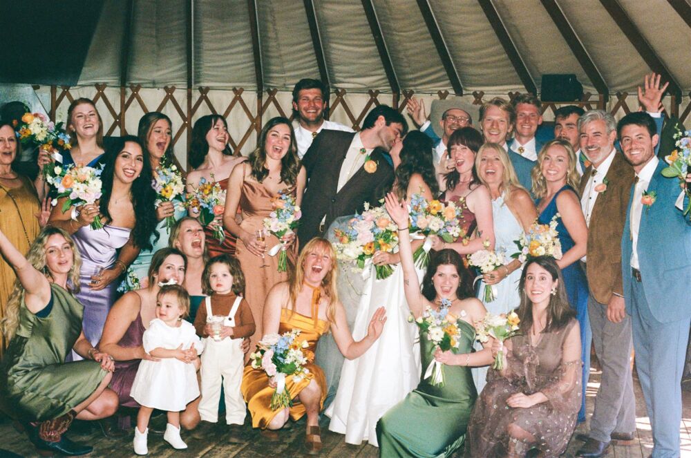 Large group of family and friends gather for a group shot at rustic boho weddings
