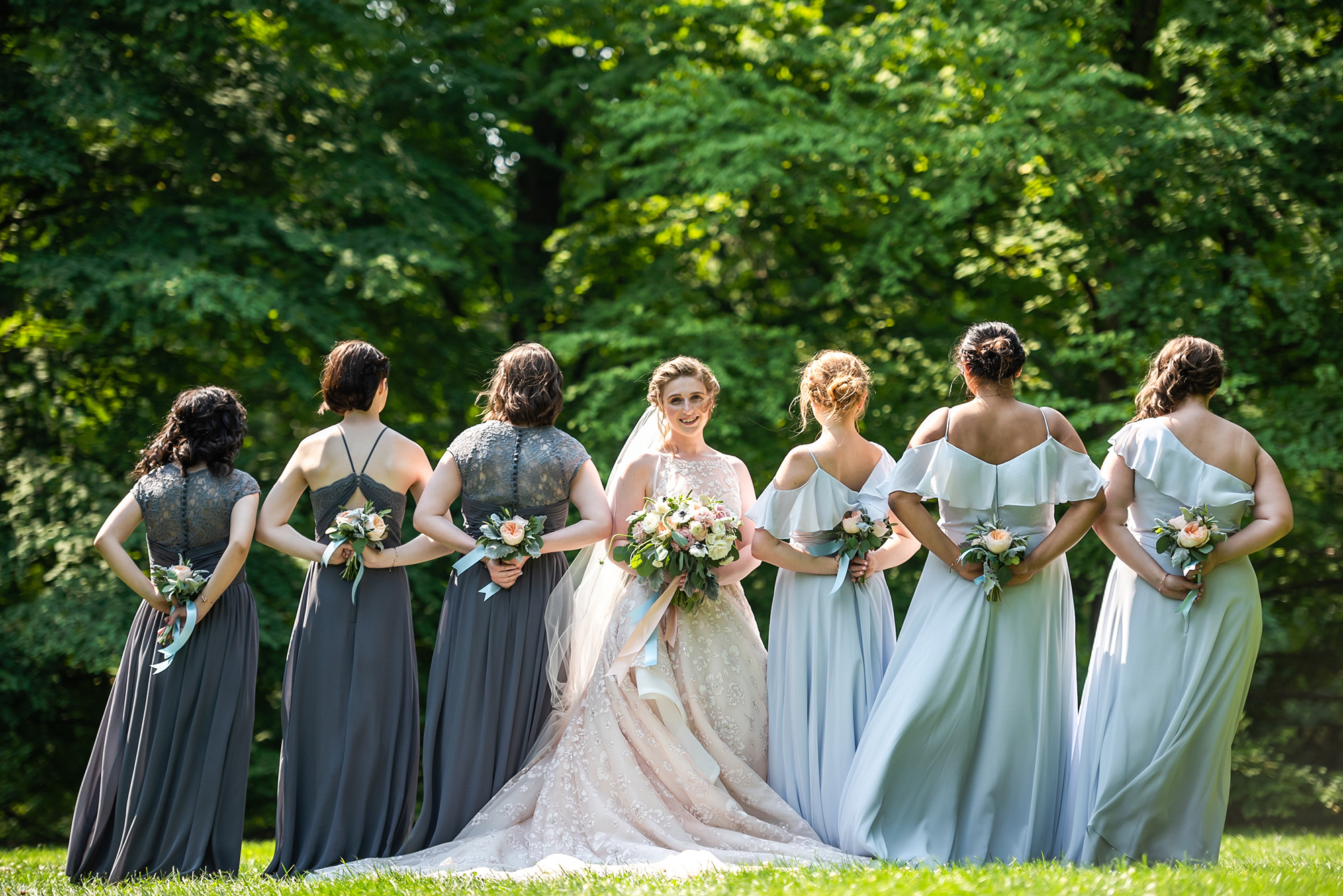 Bride looks at the camera while bridesmaids look away at rustic boho weddings
